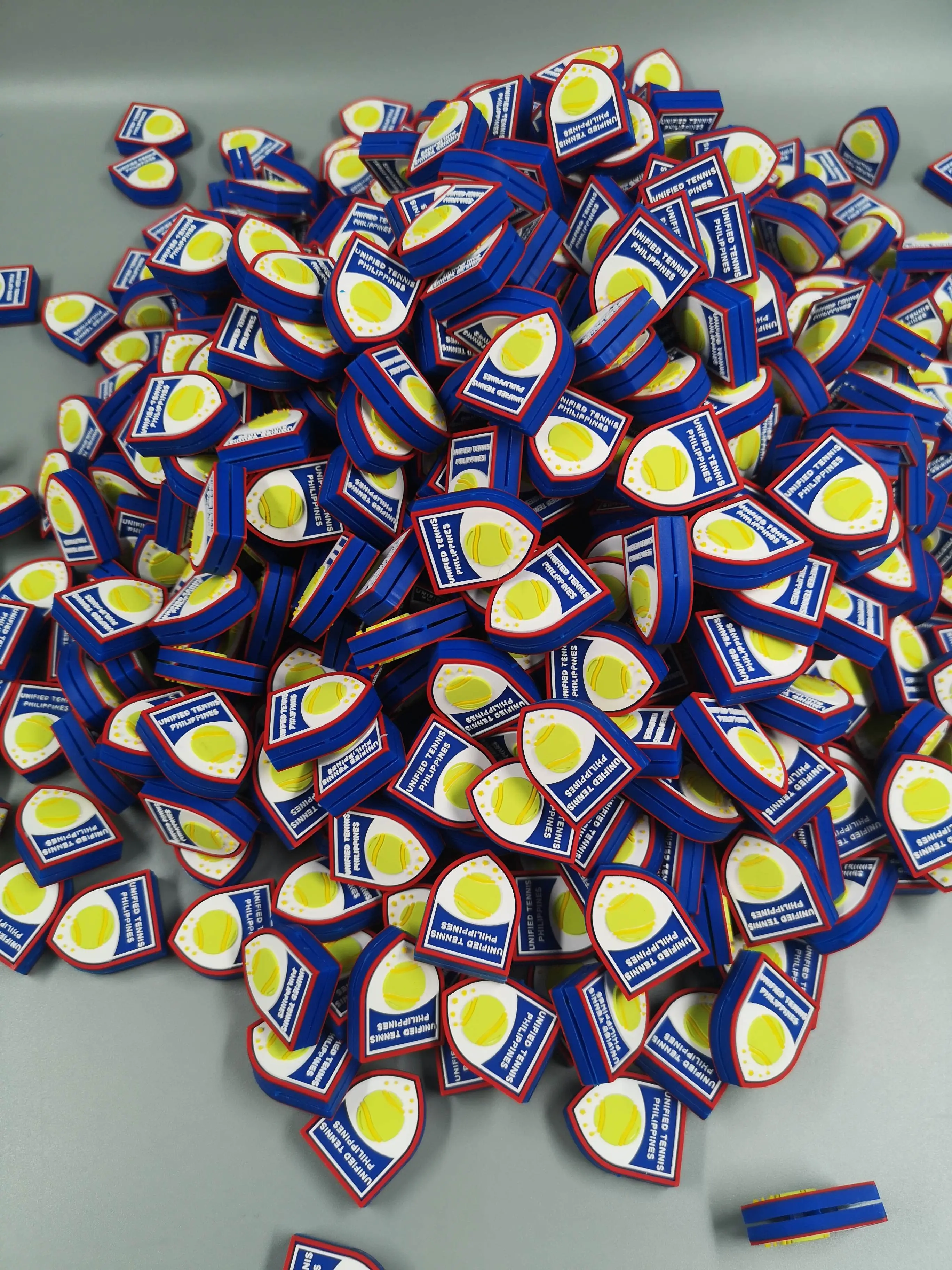 A large finished order of custom shield-shaped Unified Tennis Philippines dampeners