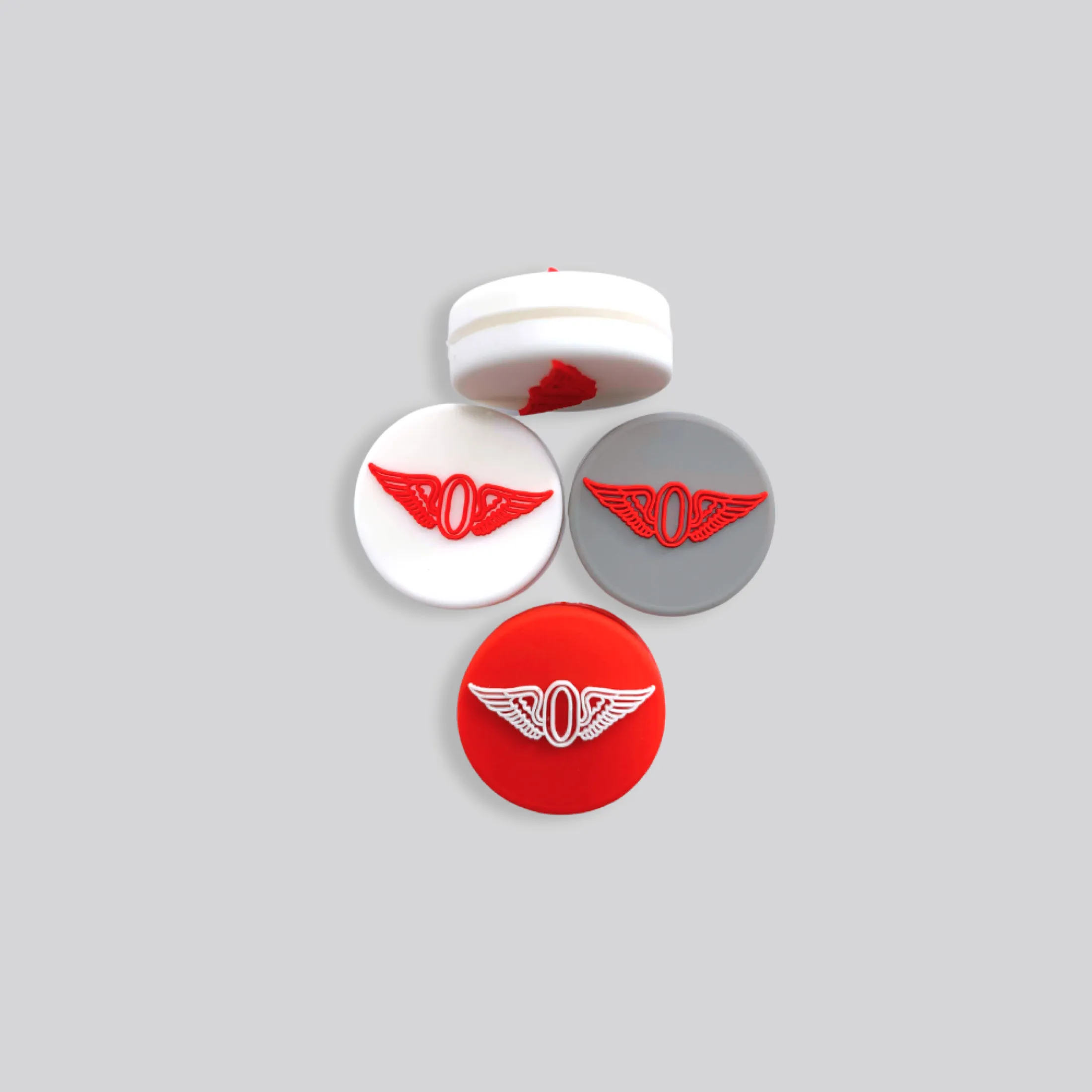Round custom dampeners with a raised winged mark in red, white, and grey